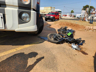 Motocicleta da vítima ao lado do caminhão com diesel. (Foto: Geniffer Valeriano/Campo Grande News)