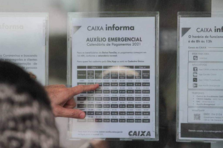 Calendário de pagamento do auxílio emergencial fixado em agência bancária, durante a pandemia de covid-19. (Foto: Marcos Maluf, Arquivo/Campo Grande News)