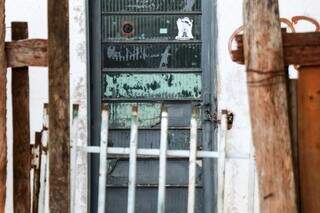 Porta da casa onde crime aconteceu trancada com corrente nesta manhã (Foto: Henrique Kawaminami)