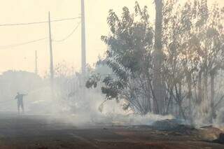 Homem tenta apagar fogo sozinho com mangueira em incêndio no bairro Taquaral Bosque (Foto: Henrique Kawaminami)