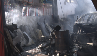 Parte interna da loja com peças e carro destruídos pelas chamas (Foto: TVC)