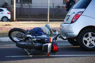 Motociclista ferido aguardando a chegada do Corpo de Bombeiros (Foto: Henrique Kawaminami)