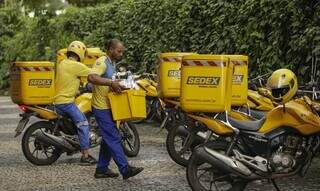 Funcionários dos Correios levam cartas até motocicletas de transporte da estatal. (Foto: Joedson Alves/Agência Brasil)