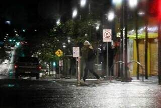 De toca e casaco, pedestre atravessa trecho da Rua 14 de Julho, Centro da Capital (Foto: Henrique Kawaminami)