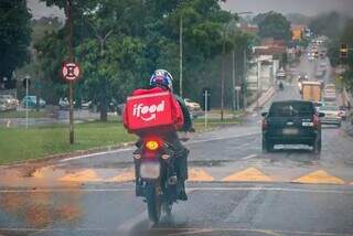 Motoboy enfrenta chuva para entregar comida (Foto: Henrique Kawaminami/Arquivo)