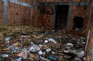 Construção abandonada está com lixo acumulado e mato. (Foto: Henrique Kawaminami)