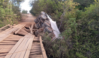 Caminhão ficou pendurado em ponte de madeira que cedeu (Foto: reprodução / Cassilândia News)