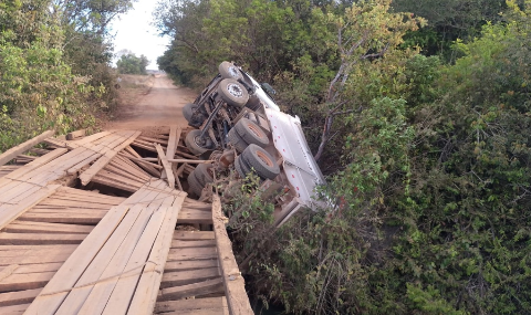 Ponte de madeira cede e caminhão fica pendurado em estrutura 