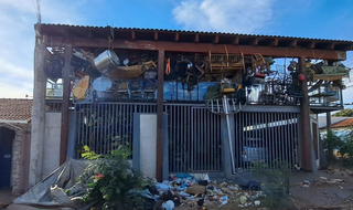 Fachada da residência repleta por lixo (Foto: reprodução / auto de prisão)