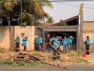 Trabalhadores fazendo a limpeza da área externa na manhã desta quinta-feira (Foto: Bruna Marques)