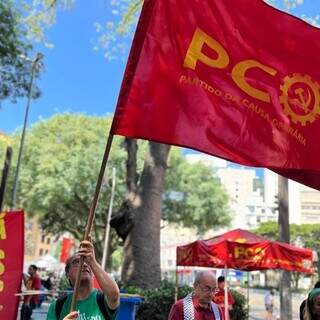 Membro do PCO com bandeira em via pública (Foto: Divulgação/PCO)