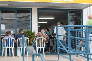 Candidatos aguardam atendimento sentados em frente a agência municipal de empregos, instalada na Rua 14 de Julho. (Foto: Paulo Francis/Arquivo do Campo Grande News)