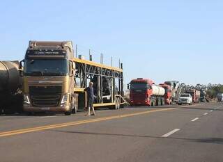 Caminhões aguardam em fila dupla para prosseguir pela BR-163 (Foto: Osmar Veiga)