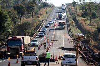 Veículos passando ao lado da parte da rodovia que desabou (Foto: Henrique Kawaminami)