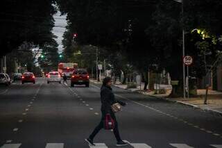 Bem agasalhada, pedestre atravessa via no Centro de Campo Grande (Foto: Henrique Kawaminami)