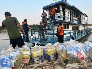 Militares descarregam cestas básicas de barco, no Rio Paraguai em Corumbá (Foto: Divulgação PMA)