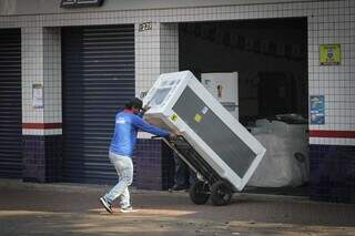 Funcionário de loja de eletrodomésticos carregando geladeira (Foto: Marcos Maluf)