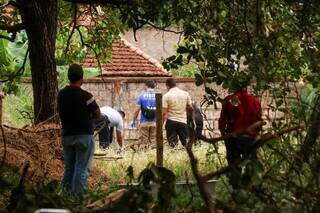 Peritos e policiais civis próximos ao corpo de idoso encontrado em terreno (Foto: Henrique Kawaminami)