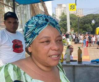 A ambulante Iara Faria explica que levou uma variedade de comidas, como pastel, kibe e coxinha para vender durante desfile (Foto: Clara Farias)