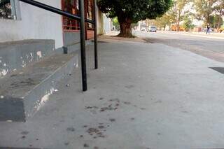 Marca de sangue na calçada da tabacaria, no Bairro Maria Aparecida Pedrossian (Foto: Juliano Almeida)