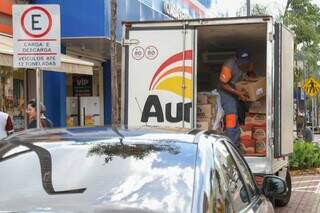 Trabalhador descarregando caminhão no centro de Campo Grande (Foto: Arquivo/Campo Grande News)