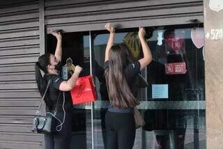 Mulheres abrindo porta de loja no Centro de Campo Grande (Foto: Marcos Maluf)