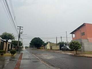 Rua com asfalto molhado e céu fechado no Jardim Água Boa em Dourados neste sábado (Foto: Helio de Freitas) 