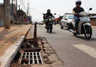 Para alertar quem passa pela Avenida Euler de Azevedo, moradores colocaram tábuas no bueiro como forma de sinalização (Foto: Osmar Veiga)