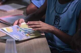 Aluno de escola municipal de Campo Grande segura caderneta de vacinação (Foto: Marcos Maluf/Arquivo)