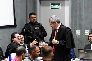 Advogado Jail Azambuja, que representa Everaldo Monteiro, oferece copo de água para promotor (Foto: Henrique Kawaminami)