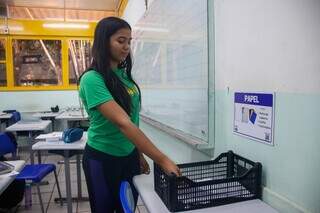 Lara faz descarte de papel em residuário colocado dentro de sala de aula (Foto: Paulo Francis)