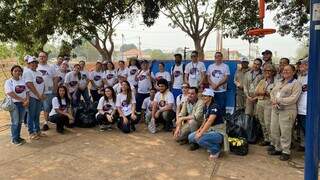 Pessoas que participaram do mutirão de limpeza e sacos de lixo, com o material recolhido (Foto: Antônio Bispo)