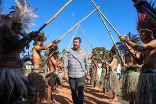 Governador Eduardo Riedel (PSDB) passa por corredor formado por indígenas que fizeram a dança da ema (Foto: Álvaro Rezende)