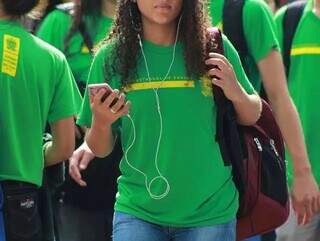 Estudante da rede estadual de ensino utiliza celular na saída da escola (Foto: Arquivo/Campo Grande News)