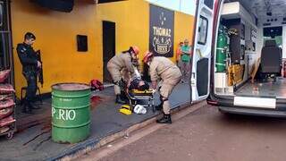 Bombeiros socorrem rapaz alvejado em conveniência; ele morreu horas depois (Foto: Leandro Holsbach)