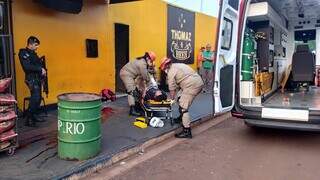 Momento que que bombeiros socorriam rapaz baleado em conveniência; ele morreu horas depois (Foto: Leandro Holsbach)