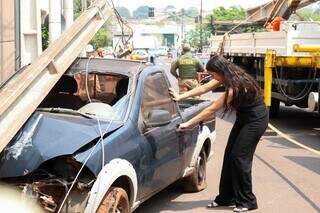 Mulher simulando acidente com carro batido na Rua Cubatão (Foto: Henrique Kawaminami)