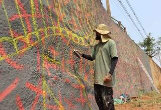 Fernando Berg pintando o viaduto da Ricardo Brandão (Foto: Osmar Veiga)