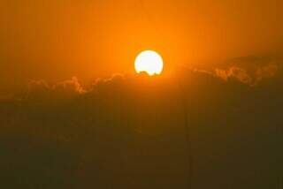 Sol forte em meio a nuvens e fumaça registrado no bairro São Francisco (Foto: Juliano Almeida)