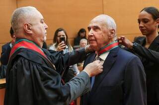 Londres Machado recebe medalha das mãos do desembargador Sérgio Martins. (Foto: Reprodução/TJMS)