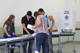 Mesários conferem nome de eleitora antes da votação (Foto: Arquivo) 