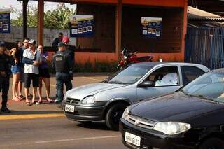 Corpo da vítima coberto por lençol dentro de carro. (Foto: Henrique Kawaminami)