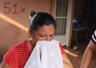 Eliane com toalha no nariz e olhos lacrimejando por conta da fumaça (Foto: Osmar Veiga)