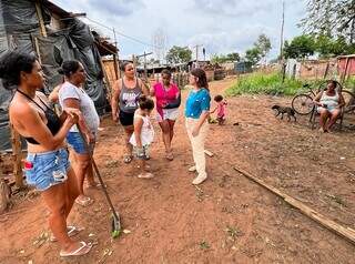 De calça clara, a defensora Regina Célia Rodrigues Magro em visita à comunidade em Campo Grande (Foto: Defensoria Pública/Divulgação)