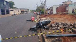 Homem ao lado do corpo de motociclista e a moto, que atingiu SUV em cruzamento (Foto: Leandro Holsbach)