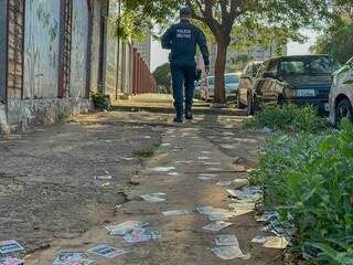 Policial militar circula em local de votação tomado por santinhos (Foto: Marcos Maluf)