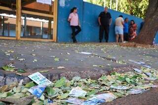 Santinhos de políticos jogados em frente a local de votação no Jardim Botafogo. (Foto: Henrique Kawaminami)