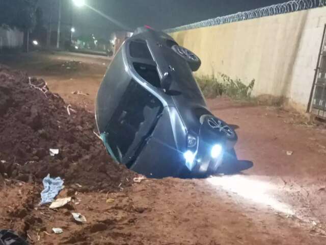 Carro cai em cratera aberta no meio da rua e dono amarga preju&iacute;zo