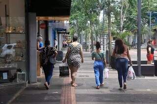 Mulheres com sacolas de compra nas mãos, na Rua 14 de Julho, em Campo Grande (Foto: Paulo Francis/Campo Grande News)