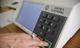 Eleitor apertando a tecla &#34;Confirma&#34; na urna eleitoral (Foto: Agência Brasil)